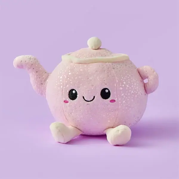 A soft pink teapot‑shaped plush toy with a smiling face, rosy cheeks, and tiny feet, shown against a pastel purple background.